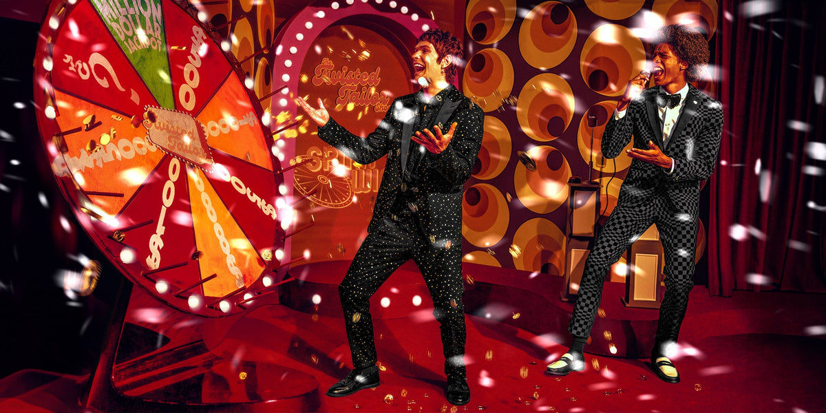 Two men in statement party suits on a game show set with falling snow